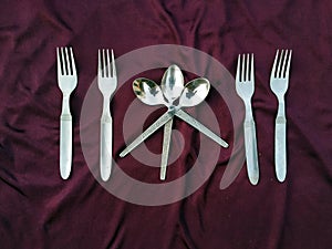 Simple set of fork and spoon isolated on violet background.