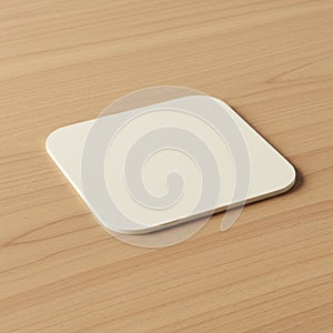 A simple, square beige coaster with rounded corners is placed on a wooden surface.