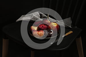 Simple still life with ripe fruit on a metal vintage plate next to a knife