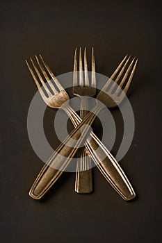 Simple still life of three gold vintage forks