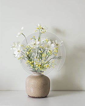 A simple summer bouquet of garden flowers in a ceramic vase on the table