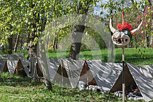 Simple tents on the festival site with in front an impaled bullhead of papier mache.