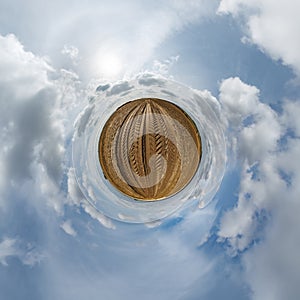 simple tiny planet without buildings in blue sky with beautiful clouds. Transformation of spherical panorama 360 degrees.