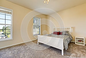 Simple upstairs bedroom with soft peach walls, gray carpet