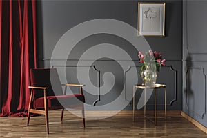 Simple waiting room interior with a single red armchair standing