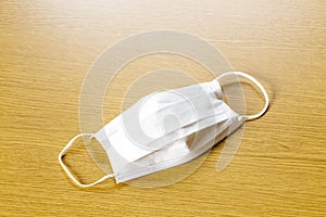 Simple white air protection mask on the color surface on blue background. Disposable surgical face mask cover the mouth and nose