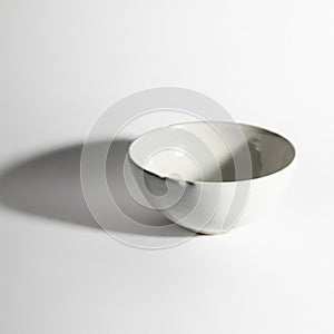 A simple white ceramic bowl is placed against a plain white background. The bowl is