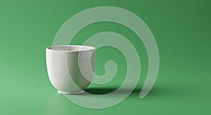 A simple white ceramic cup is placed on a green surface with a matching green