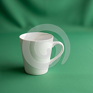A simple white ceramic mug with a curved handle is placed on a