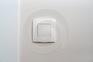 Simple white light switch, turn on or turn off the lights hanging on the white wall in the room