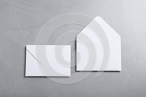 Simple white paper envelopes on light grey table, flat lay