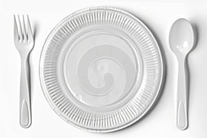 A simple white plate with a fork and a spoon, ready for use