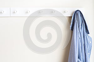 Simple white wall coat hanger with a hanging shirt