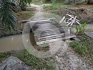 Simple wooden bridge for crossing drain pathway