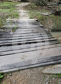 Simple wooden bridge for crossing drain pathway