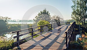 Simple wooden bridge with planks over a narrow Dutch river in th