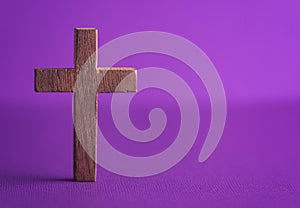 Simple Wooden Cross on a Purple Background
