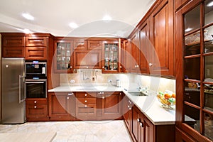 Simple wooden kitchen cupboards, countertops, refrigerator