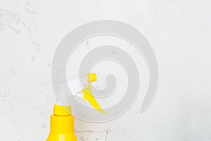 Simple yellow plastic hand spray bottle on gray background