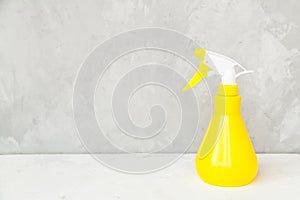 Simple yellow plastic hand spray bottle on gray background