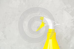 Simple yellow plastic hand spray bottle on gray background