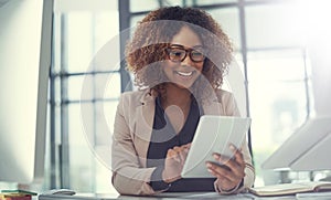 Simplifying business tasks with smart tech. a young businesswoman using a digital tablet at work.