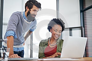 Simplifying their journey to success. two young creatives working together on a laptop in an office.