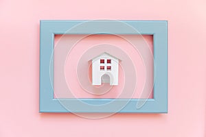 Simply design with miniature white toy house in blue frame  on pink pastel colorful trendy background