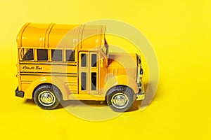 Simply design yellow classic toy car school bus isolated on yellow colorful background. Safety daily transport for kids. Back to