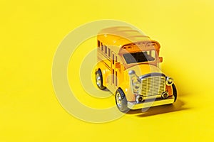 Simply design yellow classic toy car school bus isolated on yellow colorful background. Safety daily transport for kids. Back to