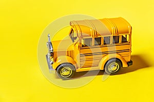 Simply design yellow classic toy car school bus isolated on yellow colorful background. Safety daily transport for kids. Back to