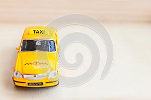 Simply design yellow vintage retro toy car Taxi Cab model on wooden background. Automobile and transportation symbol. City traffic
