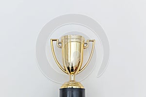 Simply flat lay design winner or champion gold trophy cup isolated on white background. Victory first place of competition.