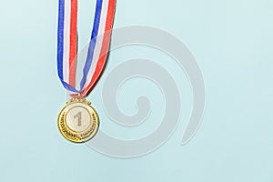 Simply flat lay design winner or champion gold trophy medal isolated on blue colorful background. Victory first place of