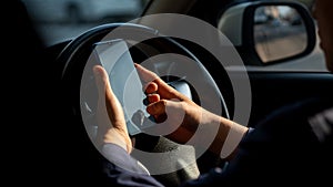Simulated picture of the driver`s hand using a smart phone, black screen inside the car, locating through a near-distance GPS navi