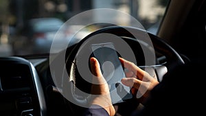 Simulated picture of the driver`s hand using a smart phone, black screen inside the car, locating through a near-distance GPS navi