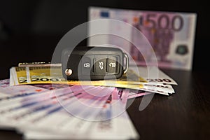 Simulation loan foCar key and Euro banknotes on brown background with shallow depth of fieldr car purchase. Five hundred