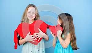 Sincere kids share tenderness and love. Girls hug red plush heart toy symbol love. Sisterhood concept. Valentines day
