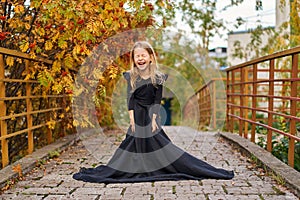 sincere laughter and closed eyes. The real happiness of a child against the backdrop of a gorgeous autumn in the city