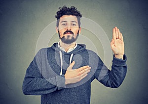 Sincere man swearing with hand on heart photo