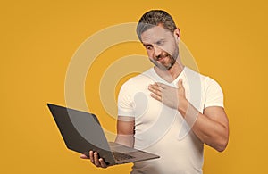 sincerely man programmer in studio. man programmer with laptop isolated on yellow background.