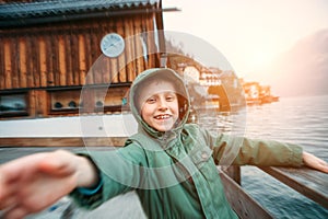 Sincerely smiling boy near the bot pier on mountain lake photo