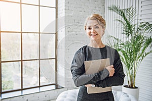 Sincerely smiling woman holding tablet