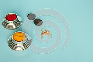 Sindoor or Kumkum silver box, areca and rice on blue background used in Hindu religion photo