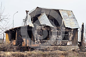 A sinful house, arson incident. Broken roof and glass windows, charred walls. Arson of a one-story private house, property