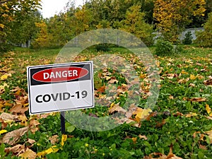 Sing danger coronavirus covid-19 on the autum park and yellow le