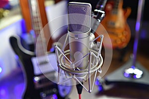 ``Sing III` Unretouched studio condenser microphone close up with instruments in the background