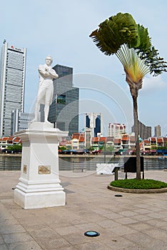 Sir Thomas Stamford Bingley Raffles statue with modern buildings at the background in Singapore, Singapore.