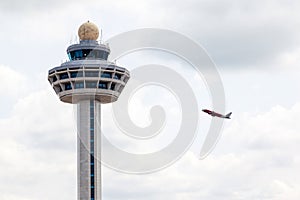 Singapore Changi Airport Traffic Controller Tower With Plane Takeoff photo