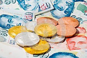 Singapore Dollar banknotes and Bitcoin Cryptocurrency coins on W